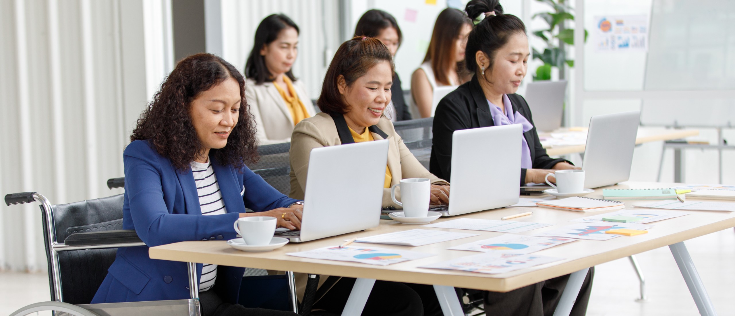 AUDIT COMMITTEE asian-middle-aged-female-handicapped-disabled-businesswoman-officer-staff-formal-business-clothing-sitting-wheelchair-working-with-other-workers-with-laptop-computer-