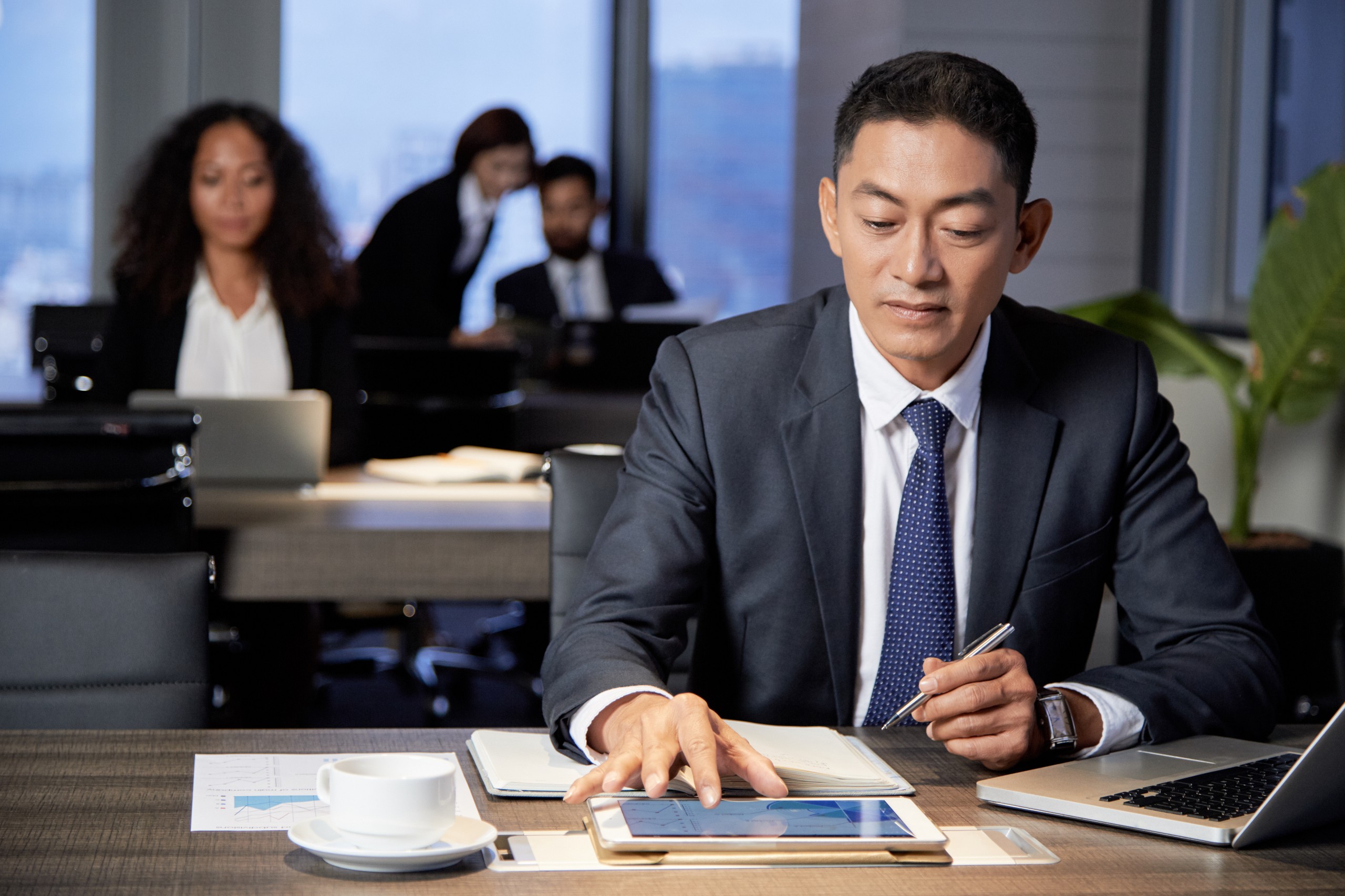 corporate disclosure policy focused-ethnic-businessman-using-tablet